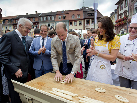 Besuch Herzogpaar von Cambridge besucht Heidelberg Marktplatz: Prinz William (3.v.r.) und Herzogin Catherine (2.v.r.) formen Brezeln, daneben Ministerpräsident Winfried Kretschmann (l.) und Heidelbergs Oberbürgermeister Prof. Dr. Eckart Würzner (2.v.l.)
