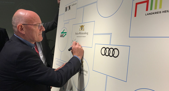 Verkehrsminister Winfried Hermann unterschreibt auf einem Plakat