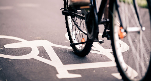 Eine Person fährt mit einem Fahrrad über einen Weg mit einem großen Fahrradsymbol.