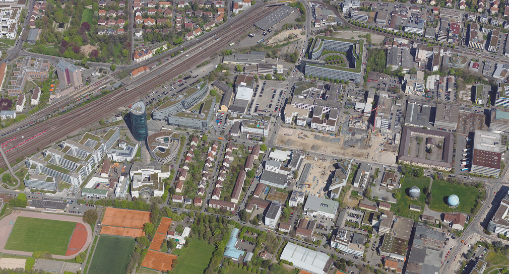 Luftbild des Bahnhof Vaihingen mit durchziehenden Schienen umgeben von vielen Häusern.