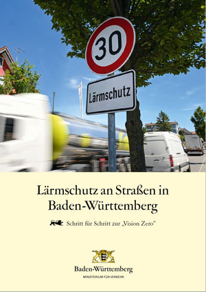 Tempo-30-Schild mit dem Hinweis auf Lärmschutz an einer innerstädtischen, viel befahrenen Straße. Darunter der Titel: "Lärmschutz an Straßen in Baden-Württemberg – Schritt für Schritt zur Vision Zero" und das Logo des baden-württembergischen Verkehrsministeriums