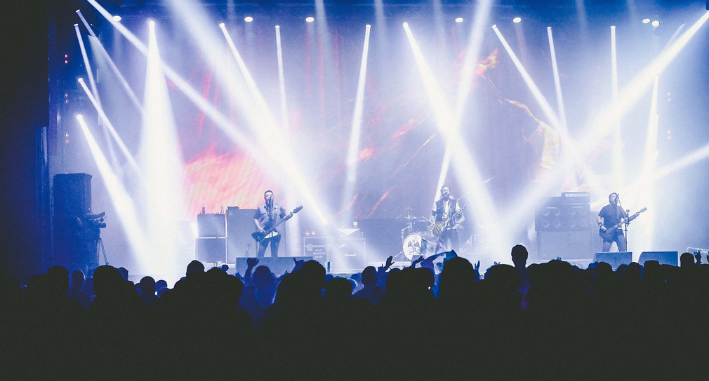 Eine Band steht bei einem Konzert auf der Bühne (pixabay/web-539757/192)
