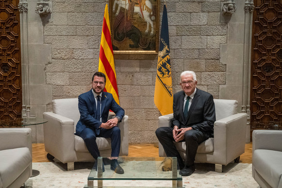 Europa Kretschmann auf Delegationsreise in Spanien Ministerpräsident Winfried Kretschmann (rechts) und Regionalpräsident Pere Aragonès (links) sitzen vor einer baden-württembergischen und einer katalonischen Fahne.