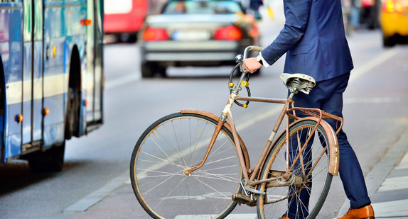 Geschäftsmann steigt in einen Bus mit seinem Fahrrad.