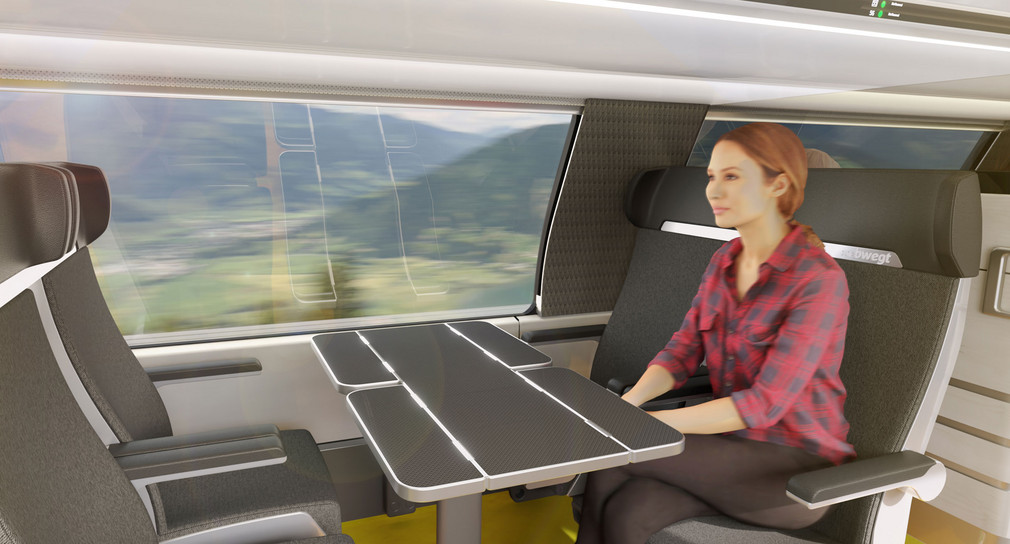 Eine Frau sitzt in einer Sitzgruppe in einem Zug.