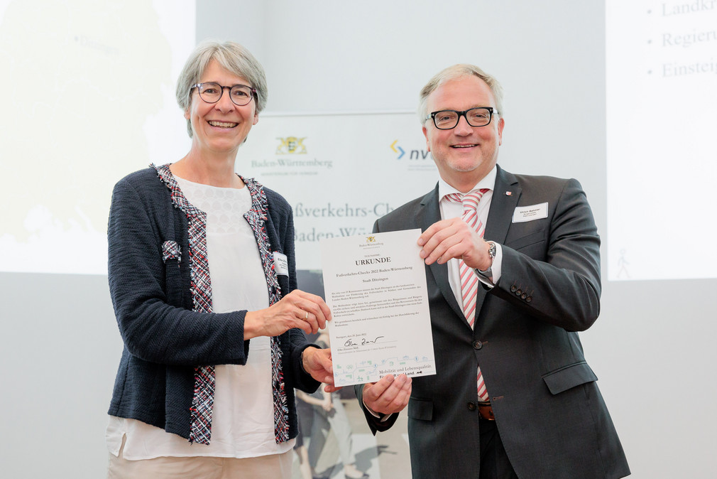 Staatssekretärin Elke Zimmer überreicht Ulrich Bahmer, Bürgermeister von Ditzingen, eine Urkunde für die Teilnahme an den Fußverkehrs-Checks 2022.