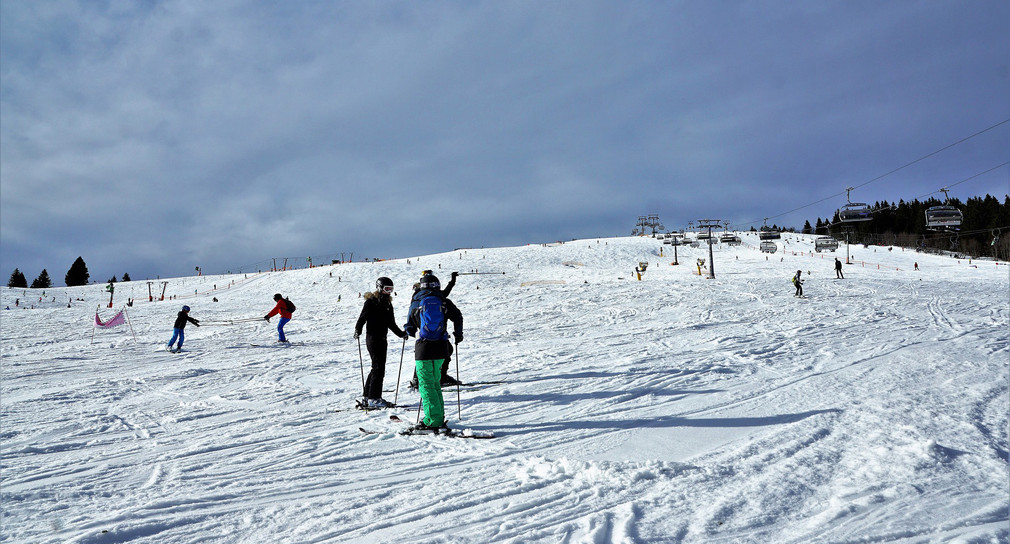 Skipiste mit Skilift und Skifahrern