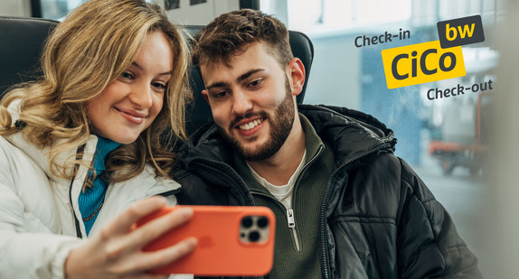 Eine Frau macht ein Selfie mit einem Mann in einem Zug. An der Fensterscheibe klebt das Logo von CiCoBW