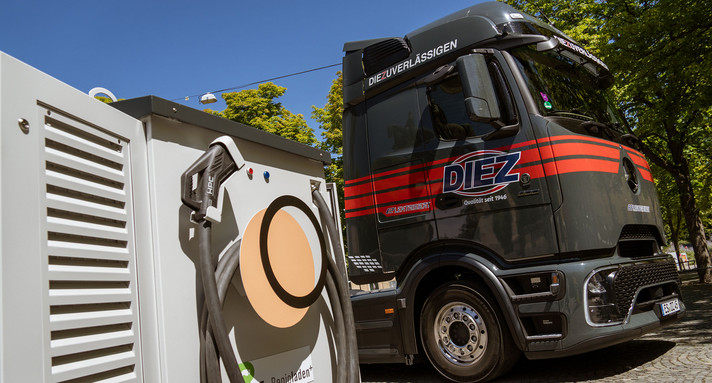 Ein E-Lkw steht vor einer Ladesäule.