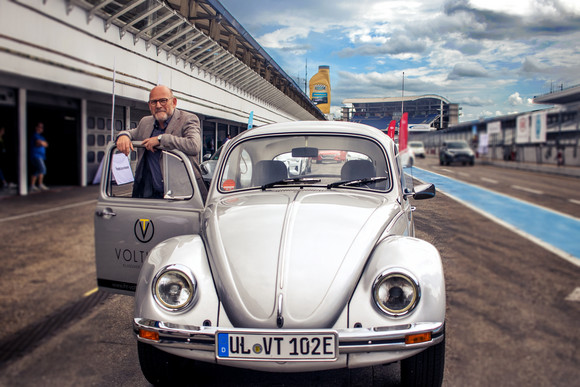 Elektromobilität e4 TESTIVAL auf dem Hockenheimring Verkehrsminister Winfried Hermann MdL mit dem auf E-Antrieb umgebauten VW Käfer von Voltimer beim e4 TESTIVAL 2019 (Bilderquelle: Kira Chaparro_© emodrom)