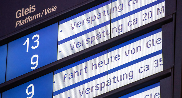 Anzeigetafel am Bahnhof zeigt Verspätungen von Zügen an.