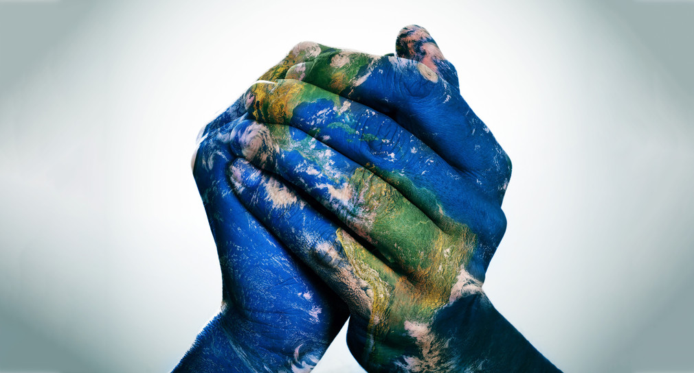 eine Weltkarte auf Menschenhänden, die einen Globus bilden (Erdkarte, bereitgestellt von der NASA)