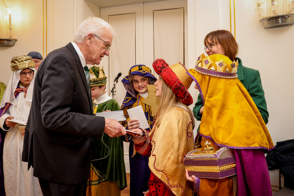 Ministerpräsident Winfried Kretschmann (links) im Gespräch mit Sternsingerinnen und Sternsingern 