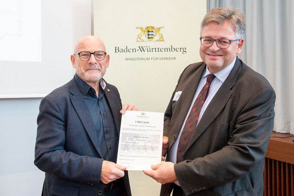 Fussverkehr 1.000 Zebrastreifen für Baden-Württemberg Winfried Hermann überreicht die Urkunde an Klaus-Peter Bitzer Leiter des Hauptamtes der Gemeinde Langenargen.