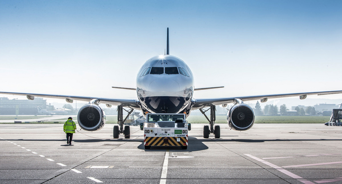 Ein Flugzeug wird von einem Pushback-Fahrzeug aufs Rollfeld geschoben.