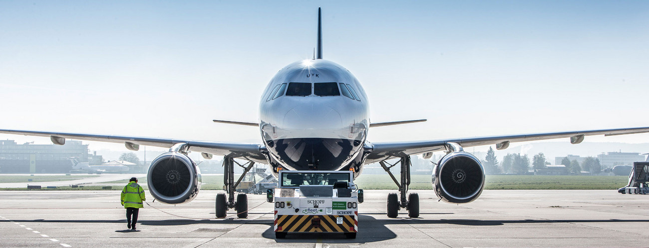 Ein Flugzeug wird von einem Pushback-Fahrzeug aufs Rollfeld geschoben.