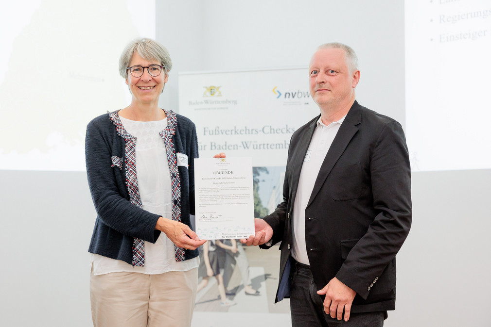 Staatssekretärin Elke Zimmer überreicht Jürgen Eberhardt, Mitglied des Gemeinderats von Mehrstetten, eine Urkunde für die Teilnahme an den Fußverkehrs-Checks 2022.