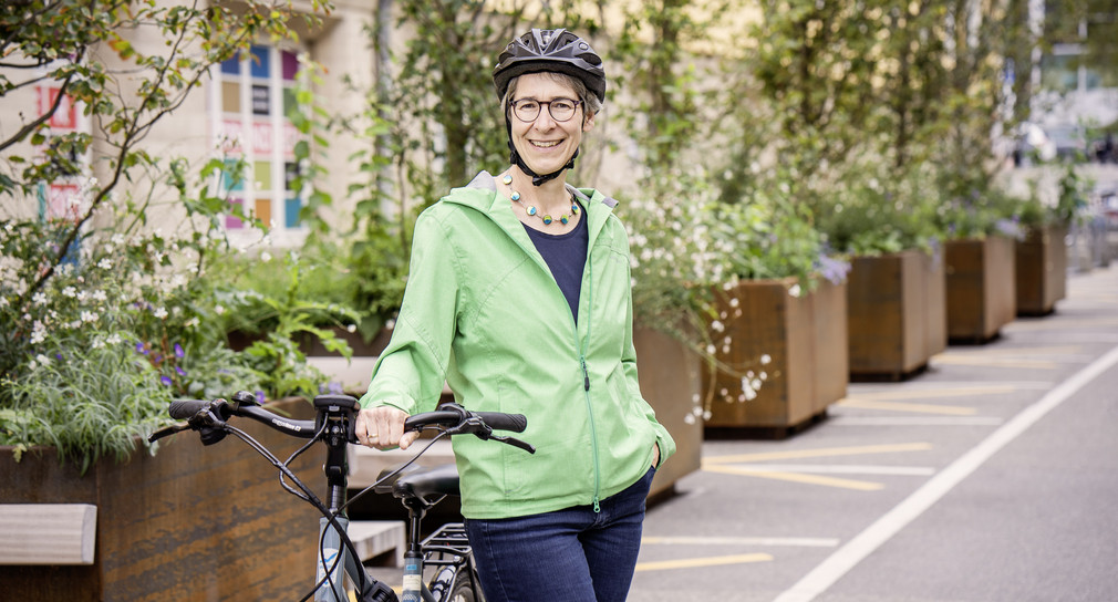 Staatssekretärin Elke Zimmer trägt einen Fahrradhelm und steht neben ihrem Fahrrad.