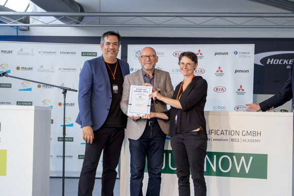 Elektromobilität e4 TESTIVAL auf dem Hockenheimring Verkehrsminister Winfried Hermann MdL bei der Übergabe der Urkunde an Dr. Sylvia Niebrügge und Louis P. Huard von Boréal Bikes / HolosceneX, einem der zwölf Finalisten des Start-up Awards 2019 im Rahmen des e4 TESTIVAL (Bilderquelle: Kira Chaparro_© emodrom)