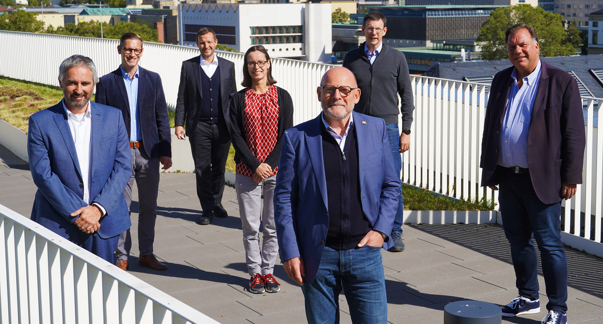 Verkehrsminister Hermann steht mit mehreren Personen auf einer Dachterrasse zu einem Gruppenfoto zusammen.