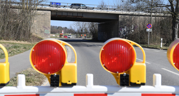 Absperrung auf einer Straße. Im Hintergrund eine Autobrücke.