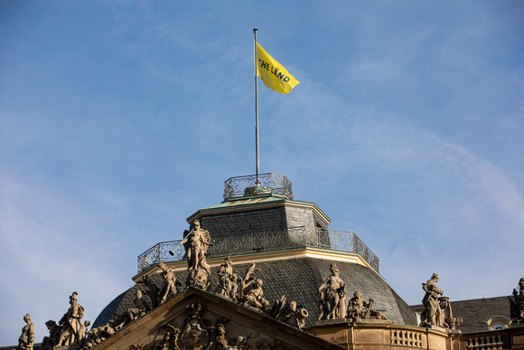 Imagekampagne Baden-Württemberg ist „THE LÄND“ Flagge auf dem Neuen Schloss in Stuttgart mit der Aufschrift „THE LÄND“