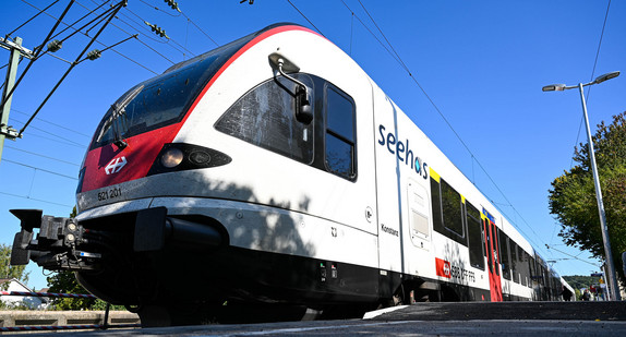 Ein Zug der Schweizerisches Bundesbahn hält an einem Bahnsteig.
