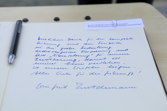 Sommertour Kretschmann wandert mit Bürgerinnen und Bürgern Eintrag von Ministerpräsident Winfried Kretschmann in das Gästebuch des Pfahlbaumuseums Unteruhldingen am Bodensee.