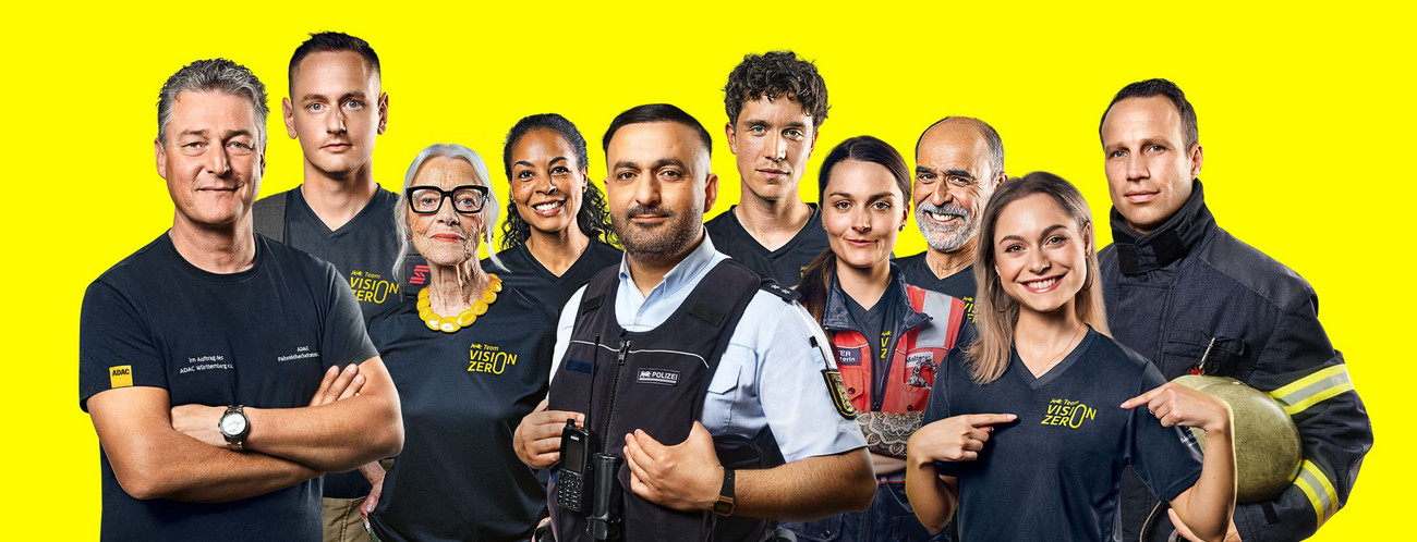 Ein Gruppenbild des Team Vison Zero. Bürger:innen, Feuerwehrleute, ein Polizist und ein Fahrsicherheitstrainer stehen nebeneinander.