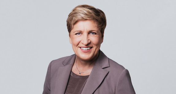 Eine Frau lacht in die Kamera.