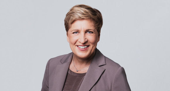 Eine Frau lacht in die Kamera.