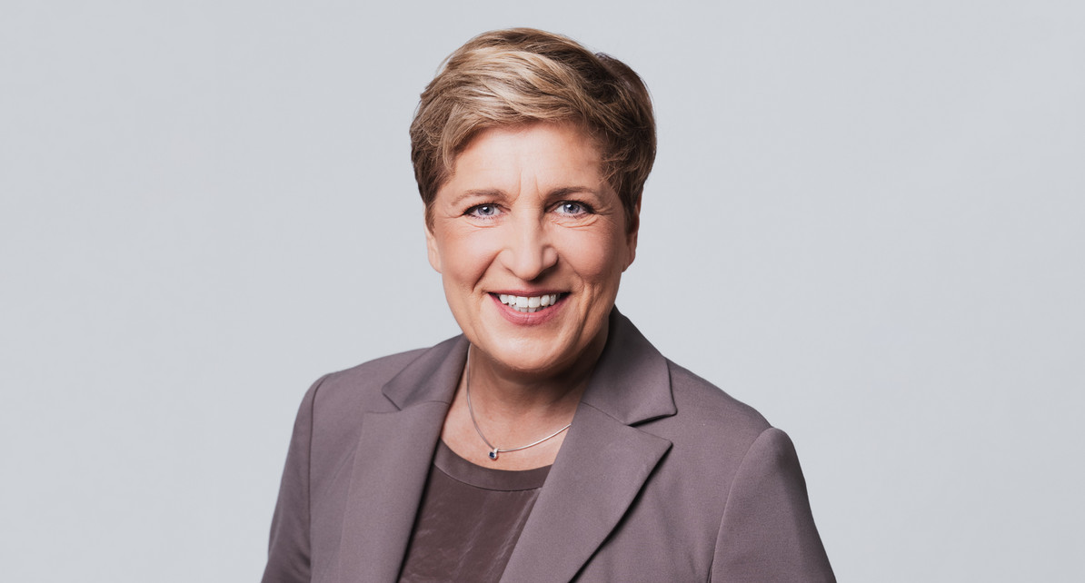 Eine Frau lacht in die Kamera.