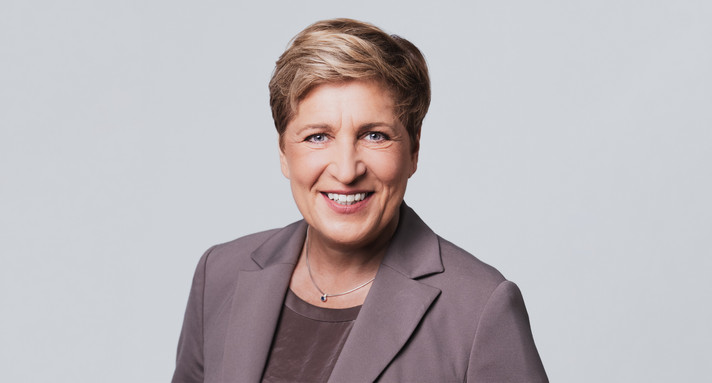 Eine Frau lacht in die Kamera.