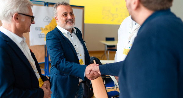 Zwei Männer schütteln die Hände zur Begrüßung.