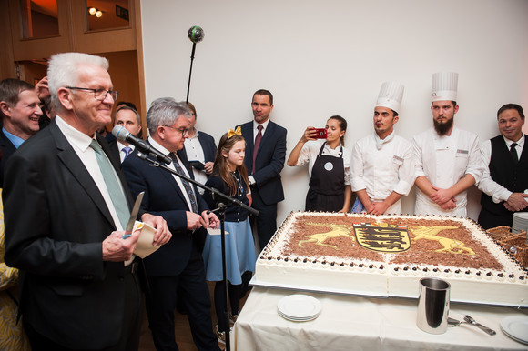 Europa Neujahrsempfang in der Landesvertretung in Brüssel Ministerpräsident Winfried Kretschmann (l.) und der Minister der Justiz und für Europa, Guido Wolf (2.v.l.), beim Anschnitt einer Baden-Württemberg-Torte (Bild: © Vertretung des Landes Baden-Württemberg bei der Europäischen Union/FKPH)