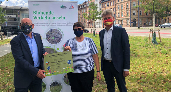 Verkehrsminister Winfried Hermann (l.) überreicht der Stadt Karlsruhe und dem Karlsruher Oberbürgermeister Frank Mentrup (r.) die Auszeichnung „Goldene Wildbiene“ (Bild: Verkehrsministerium Baden-Württemberg)