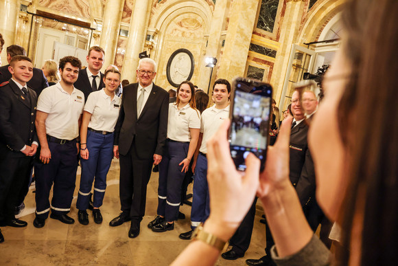 Empfang Neujahrsempfang der Landesregierung Eine Frau macht mit einem Mobiltelefon ein Foto von Ministerpräsident Winfried Kretschmann mit jungen Menschen.