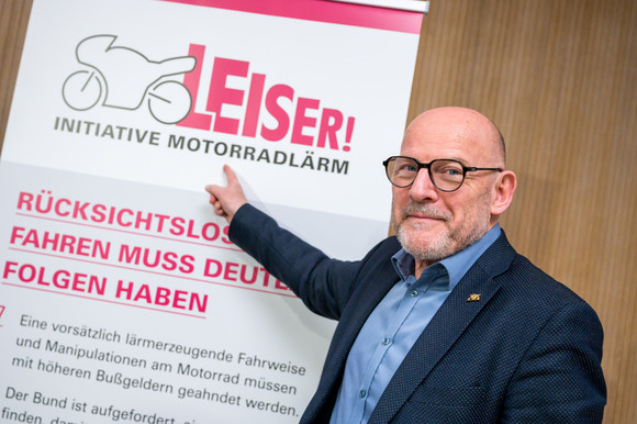 Minister Hermann zeigt auf Stellwand