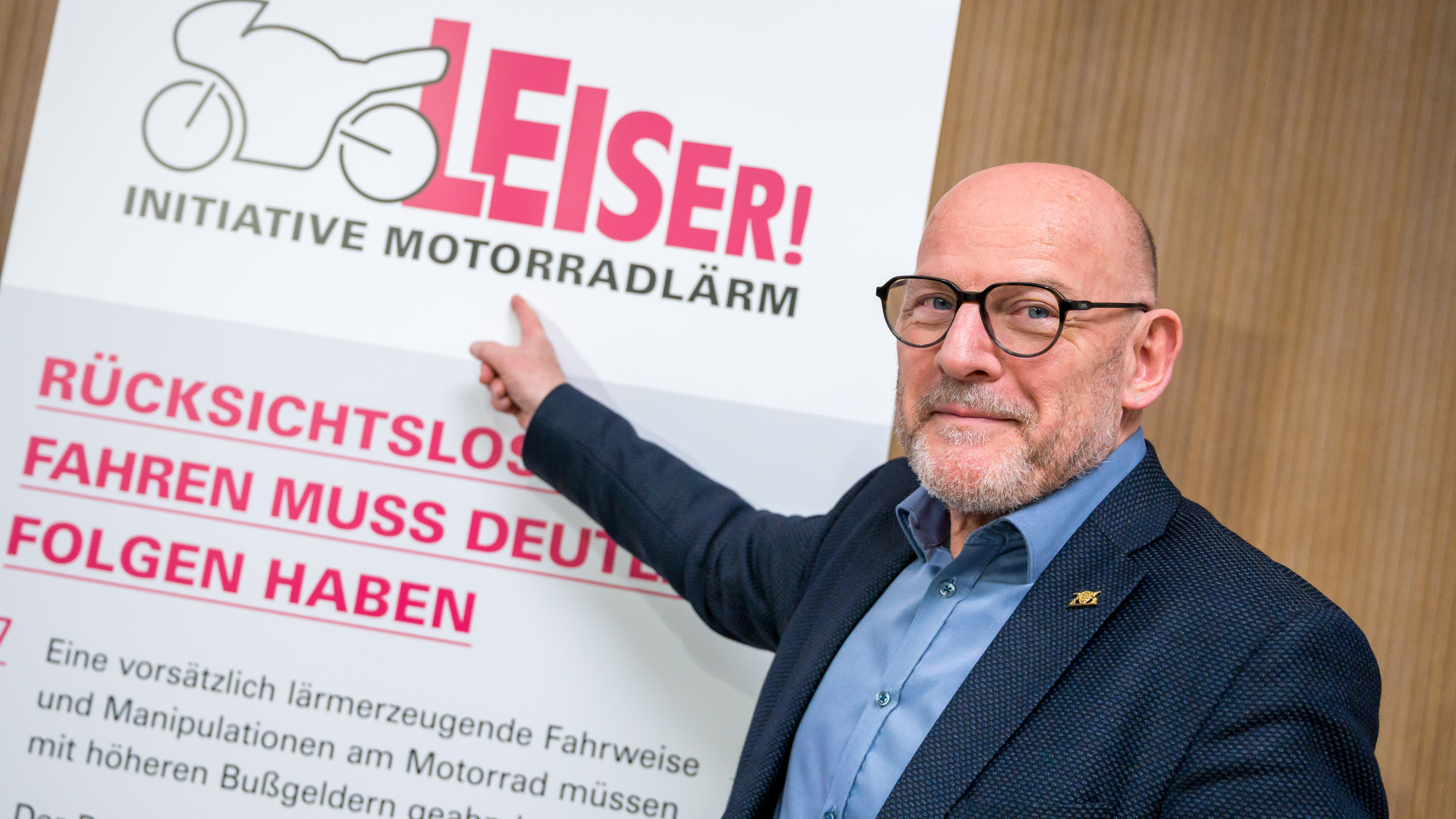 Minister Hermann zeigt auf Stellwand