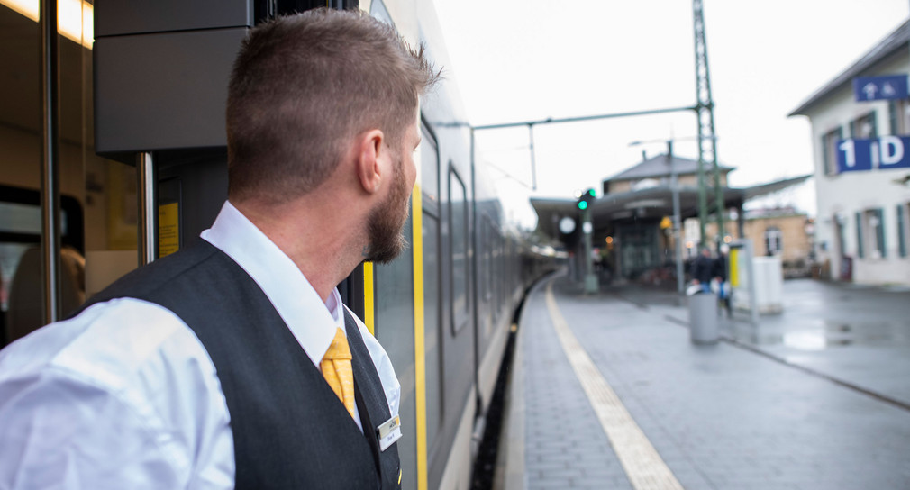 Eine Kundenbetreuer von Arverio steht an der Türe eines Zuges.