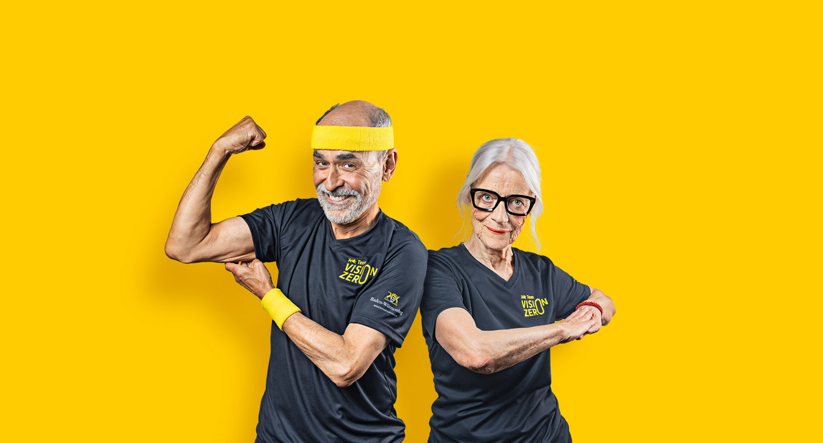 Ein Senior und eine Seniorin posieren sportlich vor einem gelben Hintergrund
