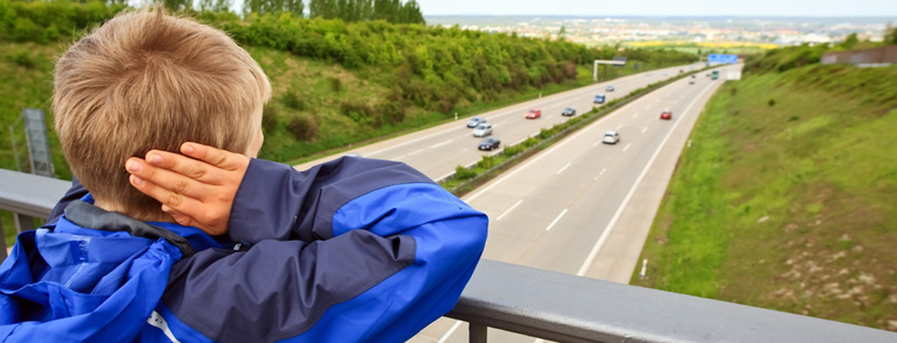 Junge auf Autobahnbrücke hält sich die Ohren zu (Bild: Fotolia.com/ miredi)