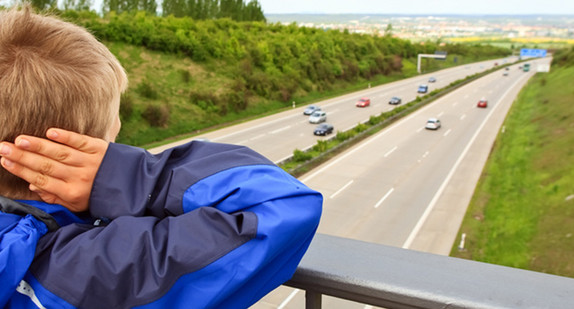 Junge auf Autobahnbrücke hält sich die Ohren zu (Bild: Fotolia.com/ miredi)