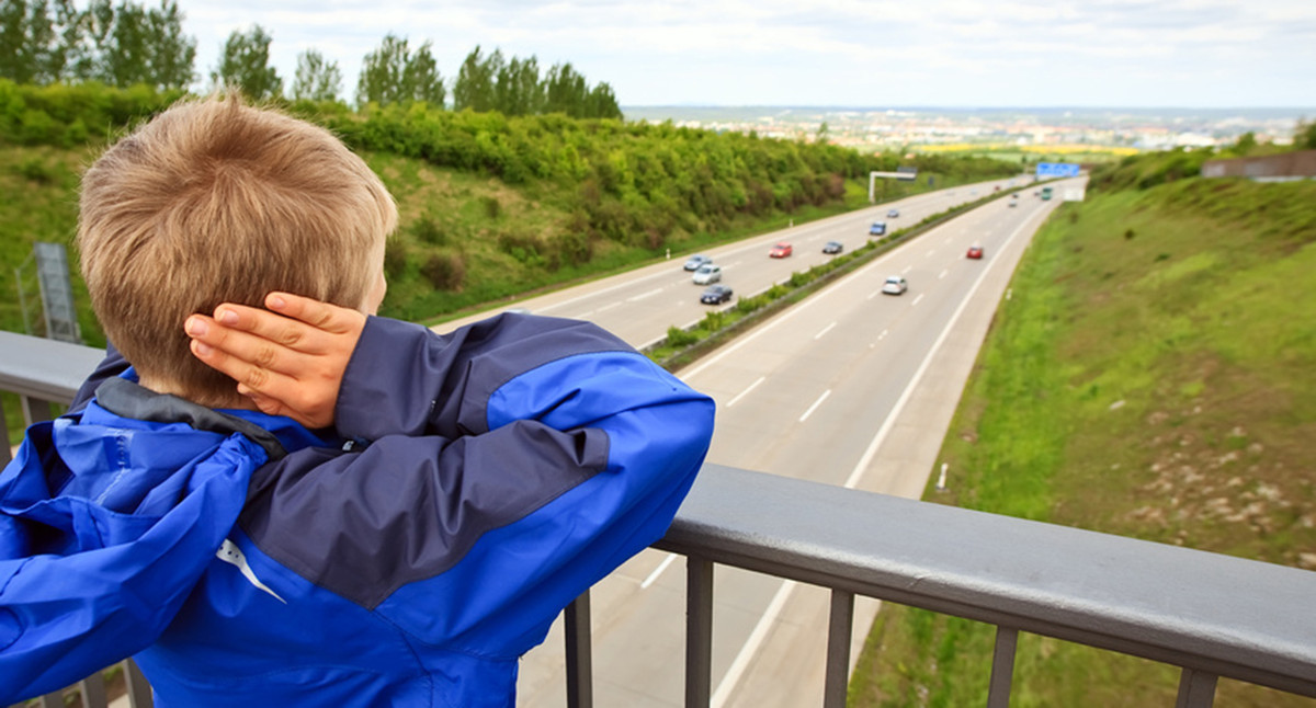 Junge auf Autobahnbrücke hält sich die Ohren zu (Bild: Fotolia.com/ miredi)