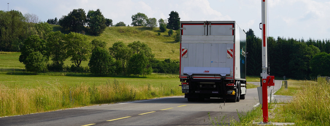 Ein Lkw fährt an einer Schranke vorbei.