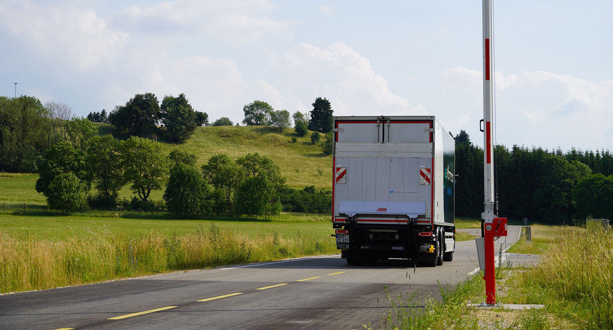 Ein Lkw fährt an einer Schranke vorbei.