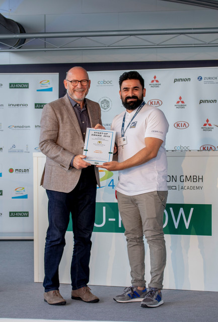 Verkehrsminister Winfried Hermann MdL bei der Übergabe der Urkunde an Sohrab Noorzaie von Sminno, einem der zwölf Finalisten des Start-up Awards 2019 im Rahmen des e4 TESTIVAL  (Bilderquelle: Kira Chaparro_© emodrom)