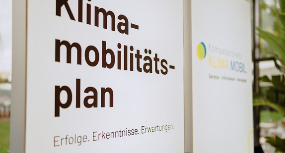 Der Titel der Veranstaltung „Klimamobilitätsplan: Erfolge. Erkenntnisse. Erwartungen“ auf einer leuchtenden Stellwand