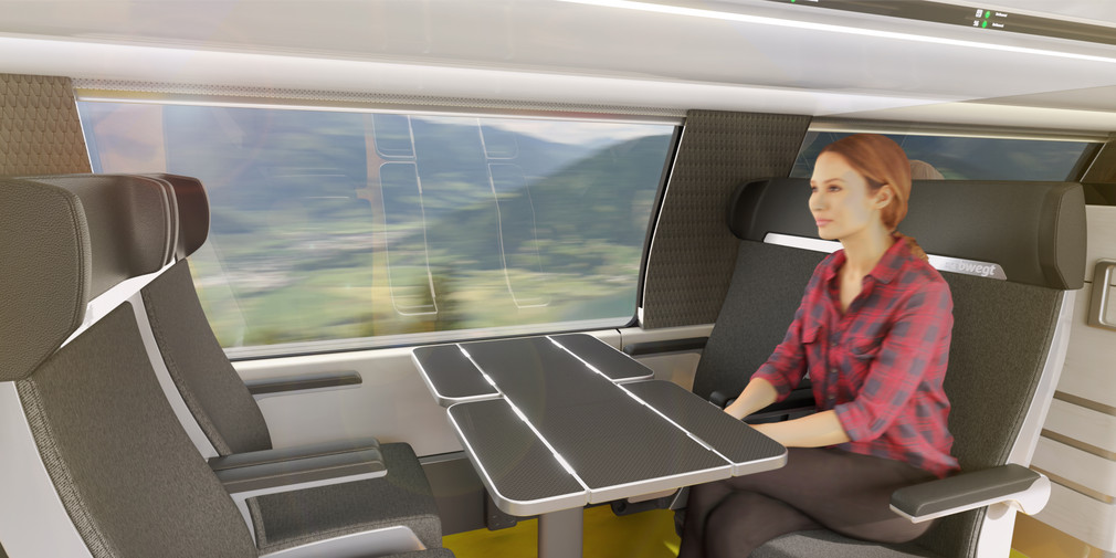 Eine Frau sitzt in einer Sitzgruppe in einem Zug.