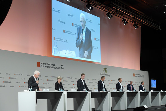 v.l.n.r.: Ministerpräsident Winfried Kretschmann spricht auf der gemeinsamen Pressekonferenz mit Wirtschaftsministerin Nicole Hoffmeister-Kraut, Ola Källenius, Vorstandsvorsitzender der Daimler AG und der Mercedes-Benz AG, Oliver Blume, Vorstandsvorsitzender der Porsche AG, Volkmar Denner, Vorsitzender der Geschäftsführung der Robert Bosch GmbH, Frank Mastiaux, Vorstandsvorsitzender der EnBW, Roman Zitzelsberger, Bezirksleiter der IG Metall Baden-Württemberg, und Brigitte Dahlbender (Video), Landesvorsitzende des Bundes für Umwelt und Naturschutz Deutschland (BUND) Baden-Württemberg